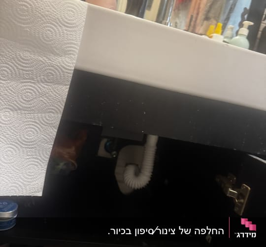 כיור עם נייר מגבת וצינור מתחת